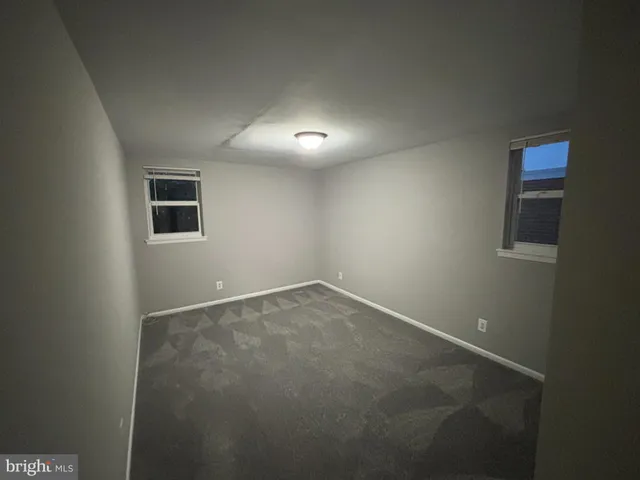 an empty room with a empty space and windows