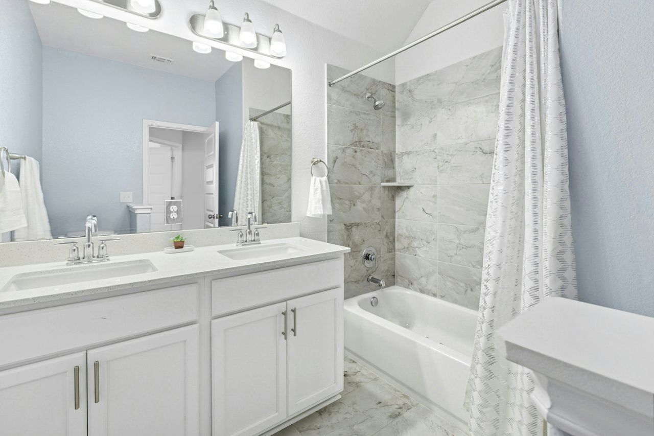 242 Backstays Loop Kyle, TX 78640 - Photo 28 of 36 a bathroom with a bathtub shower sink vanity and mirror