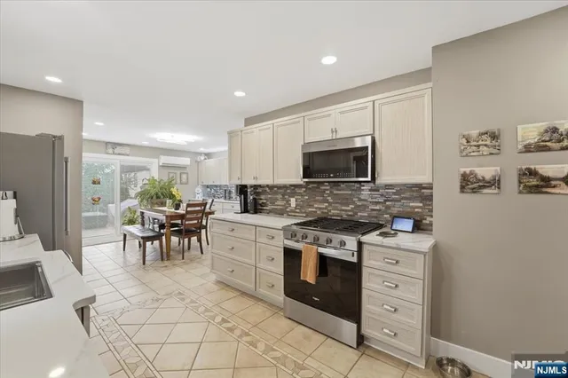 a kitchen with white cabinets and appliances