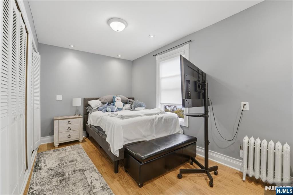 486 Devon Street Kearny, NJ 07032 - Photo 23 of 44 a spacious bedroom with a bed and a chandelier