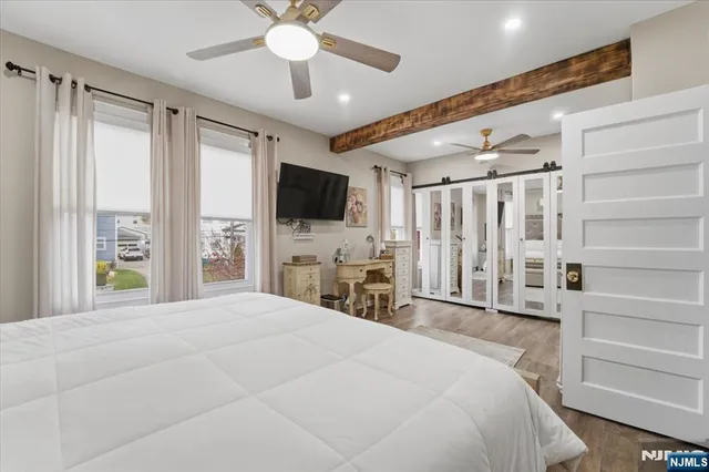 a large bedroom with a bed and a flat screen tv