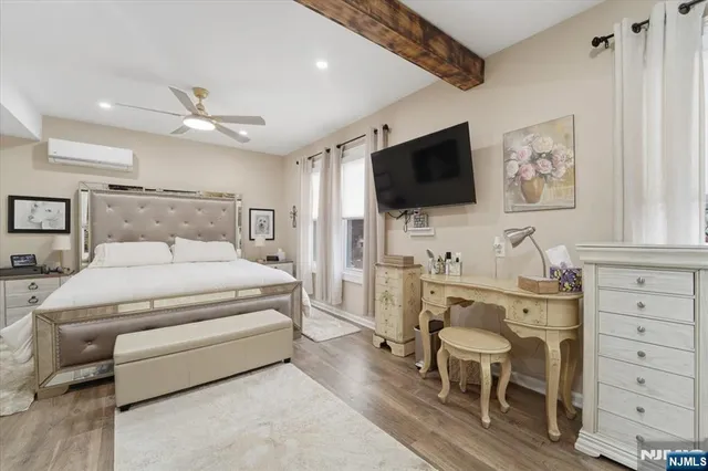 a spacious bedroom with a bed and a flat screen tv