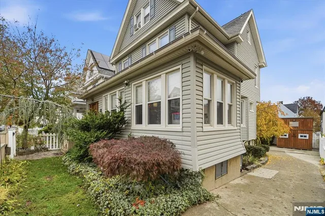 a view of a house with a yard and potted plants