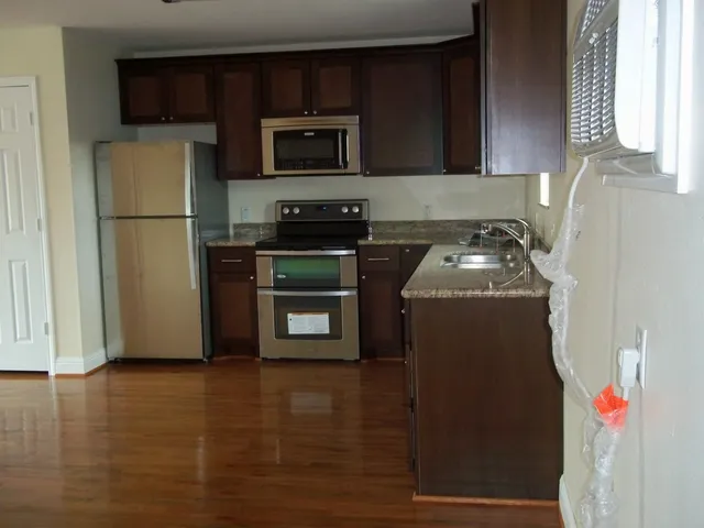 a kitchen with stainless steel appliances granite countertop a refrigerator sink and stove