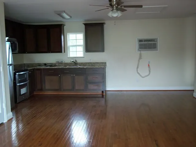 a kitchen with granite countertop a stove a sink and a refrigerator