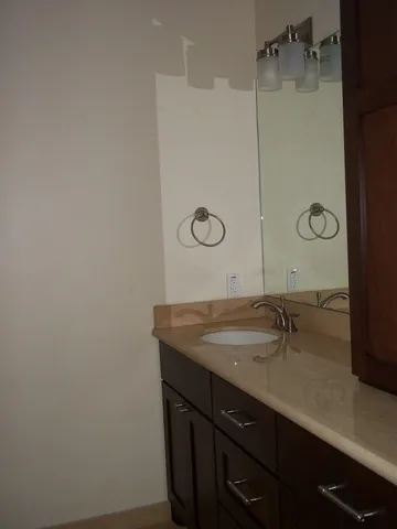a bathroom with a granite countertop sink and a mirror
