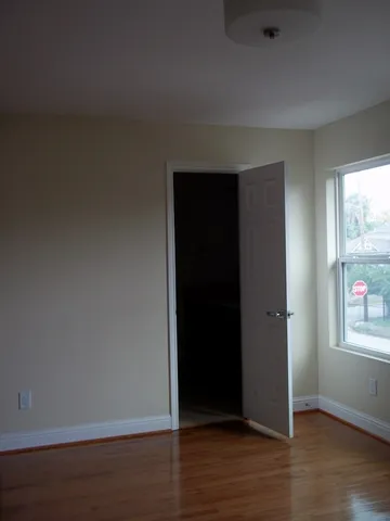 an empty room with wooden floor and closet