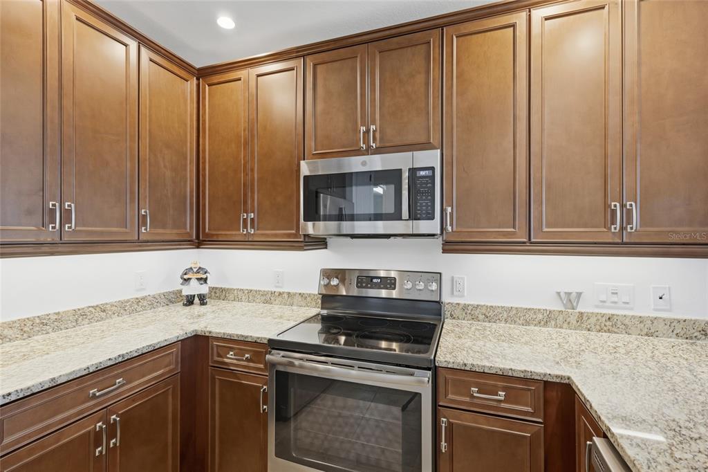 10520 Boardwalk Loop, Unit 301 Bradenton, FL 34202 - Photo 12 of 55 a kitchen with granite countertop cabinets stainless steel appliances and a sink