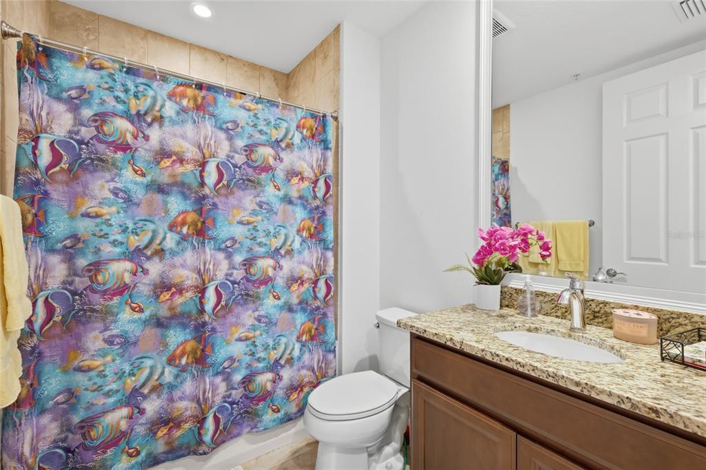 10520 Boardwalk Loop, Unit 301 Bradenton, FL 34202 - Photo 24 of 55 a bathroom with a granite countertop sink a toilet and a shower curtain