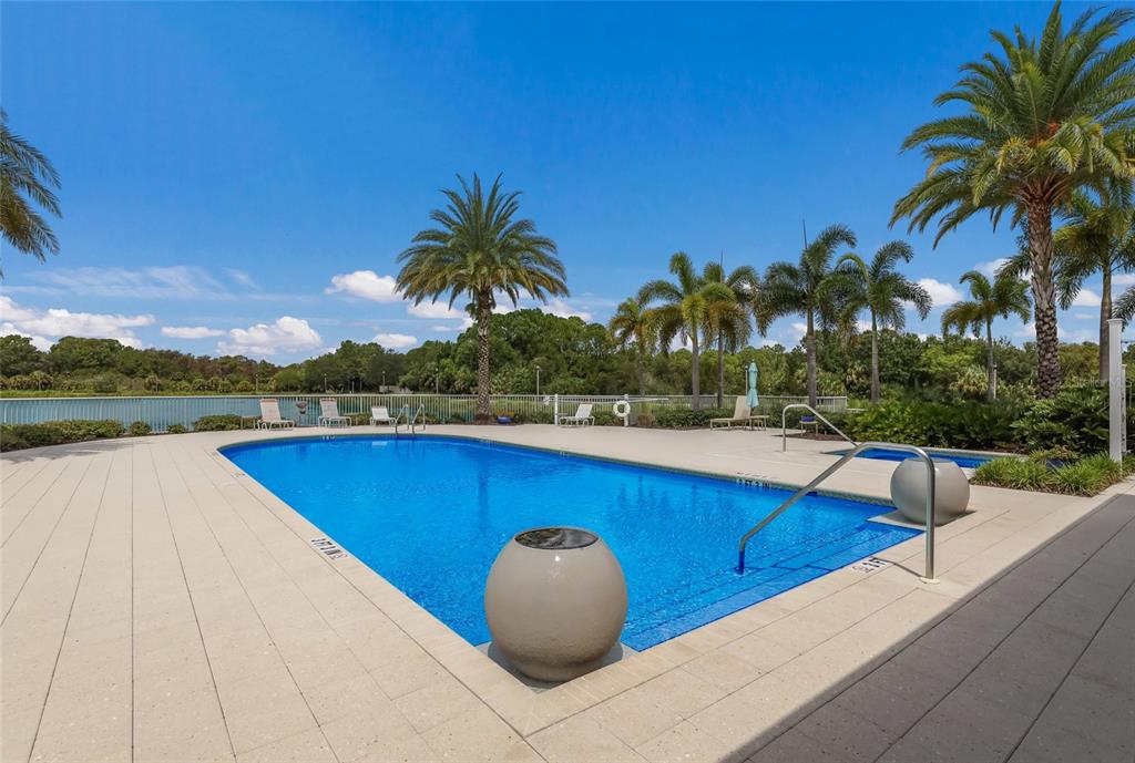 10520 Boardwalk Loop, Unit 301 Bradenton, FL 34202 - Photo 36 of 55 a view of a swimming pool with a table and chairs