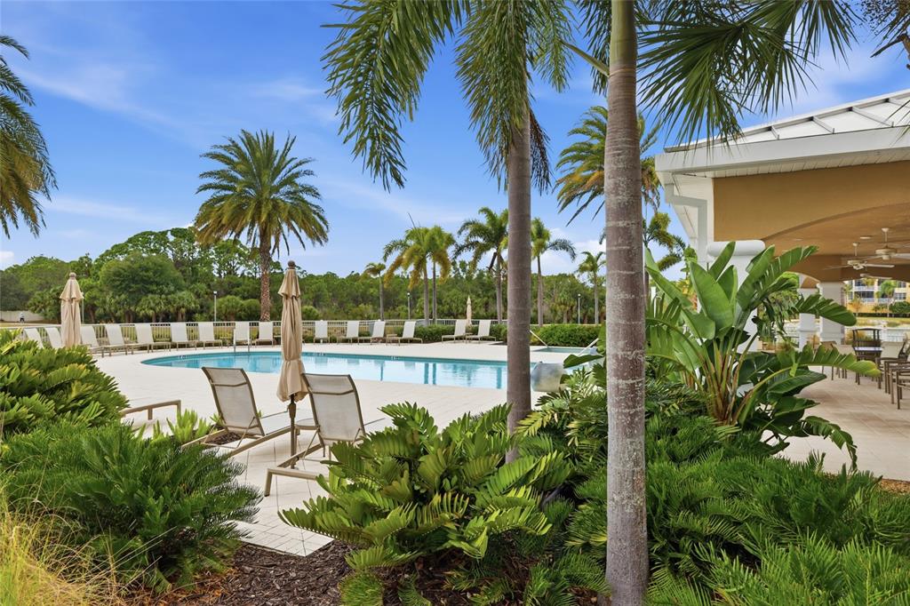 10520 Boardwalk Loop, Unit 301 Bradenton, FL 34202 - Photo 38 of 55 a view of a swimming pool with a garden and patio