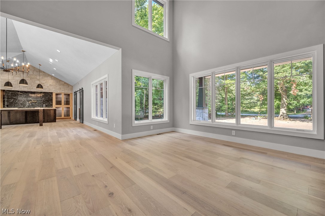 4009 Brainard Road Beachwood, OH 44122 - Photo 14 of 50 living room featuring light hardwood / wood-style floors, a chandelier, and high vaulted ceiling