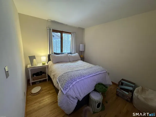 a bedroom with a bed and wooden floor