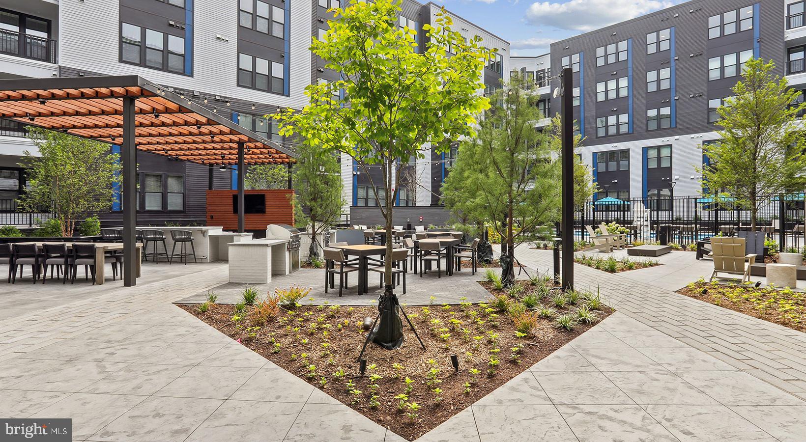 4851 Ellin Road, Unit 239 Hyattsville, MD 20784 - Photo 2 of 15 a view of a patio with dining table and chairs with plants