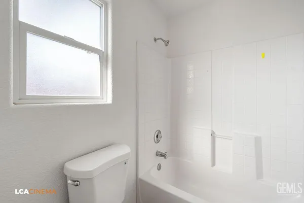 a view of an empty room with wooden floor and closet