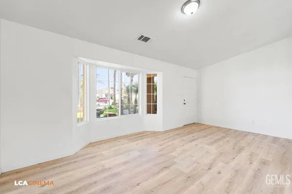 an empty room with wooden floor and a window