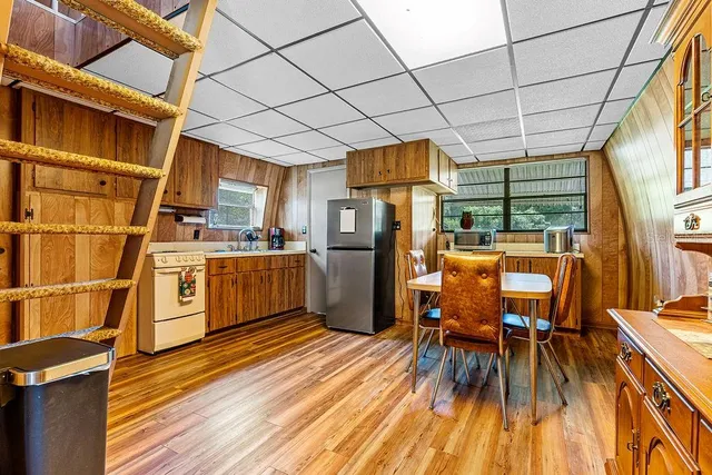 a kitchen with stainless steel appliances a refrigerator a table and chairs