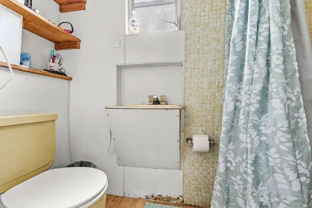 a white toilet sitting next to a shower curtain