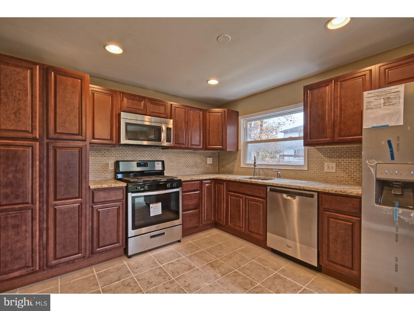 245 Winding Way Road Stratford, NJ 08084 - Photo 10 of 21 a kitchen with stainless steel appliances granite countertop a stove sink microwave and window