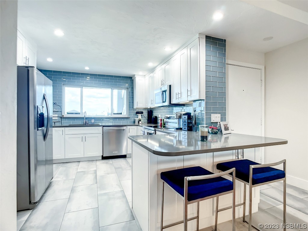 6584 Engram Road, Unit D302 New Smyrna Beach, FL 32169 - Photo 23 of 39 a kitchen with stainless steel appliances granite countertop a refrigerator sink and cabinets