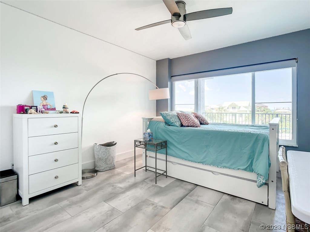 6584 Engram Road, Unit D302 New Smyrna Beach, FL 32169 - Photo 27 of 39 a bedroom with a bed and large windows