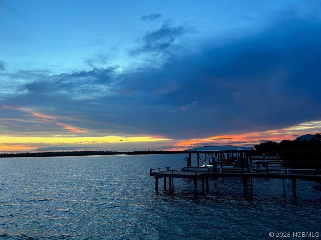 6584 Engram Road, Unit D302 New Smyrna Beach, FL 32169 - Photo 38 of 39 a view of a swimming pool with a table and chairs under an umbrella