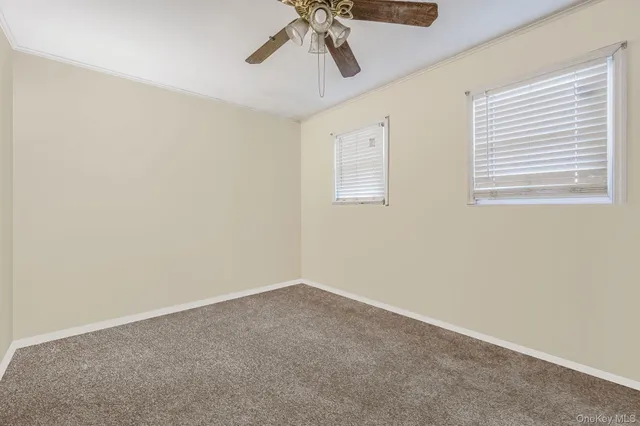 a view of a room with a ceiling fan and window