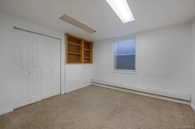 an empty room with windows and closet