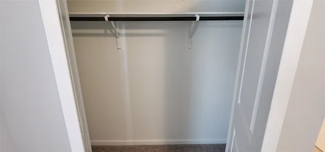 a view of hallway with window and wooden floor