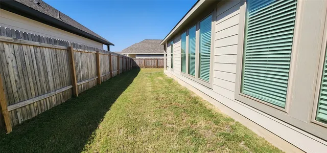 a view of a backyard with wooden fence