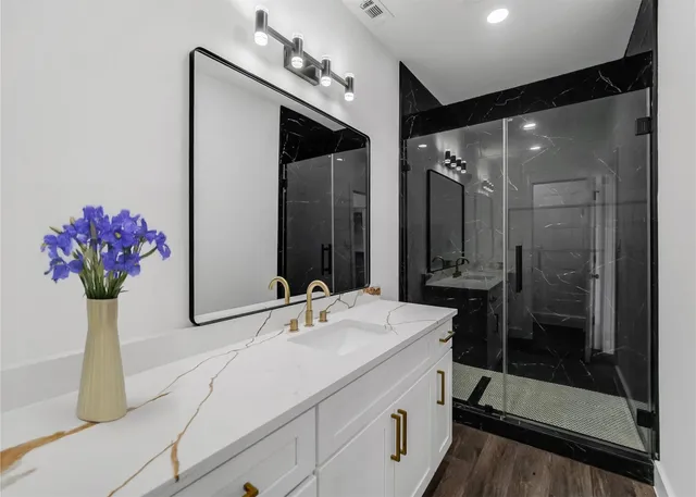 a bathroom with a shower sink and mirror