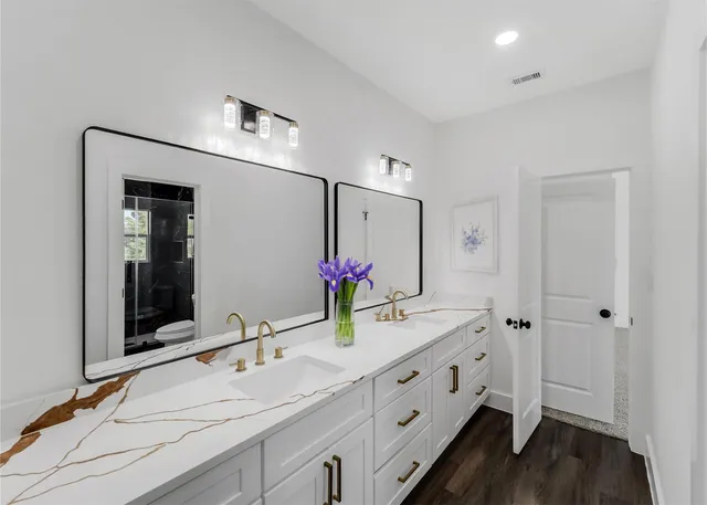 a bathroom with double vanity and a mirror