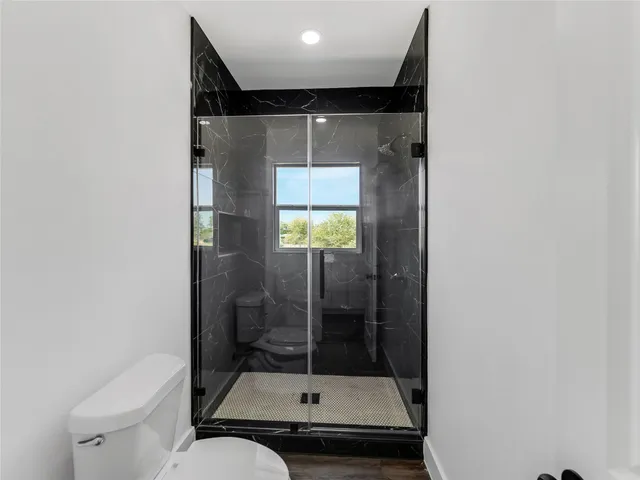 a bathroom with a toilet a sink and shower