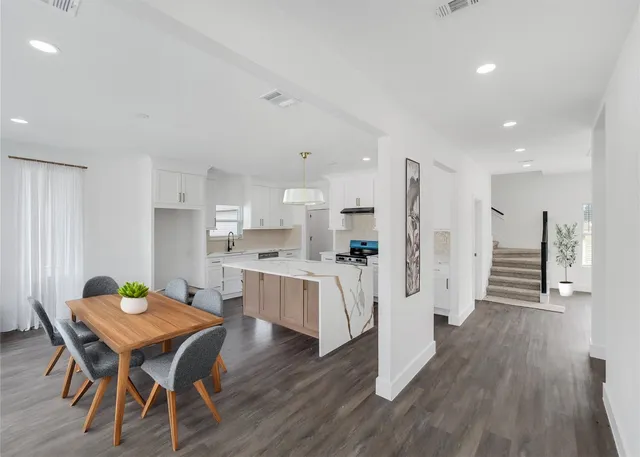 a open dining room with kitchen island wooden floor and refrigerator