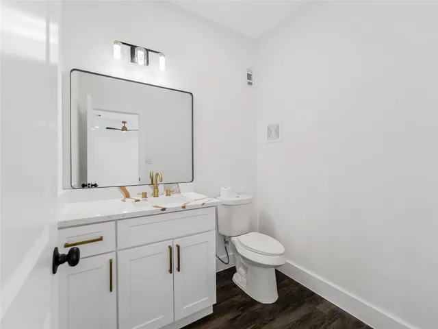 a bathroom with a toilet a sink and mirror