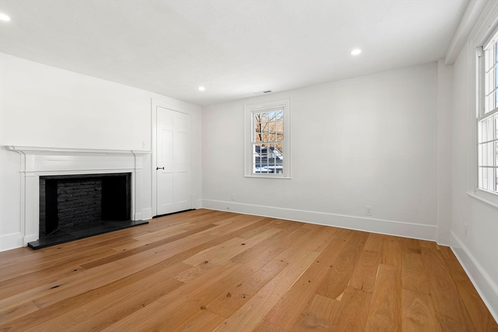 34 Central Street, Unit 2 Rowley, MA 01969 - Photo 13 of 29 an empty room with wooden floor and fireplace