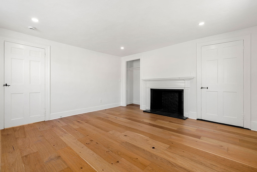34 Central Street, Unit 2 Rowley, MA 01969 - Photo 15 of 29 a view of an empty room with wooden floor and a fireplace