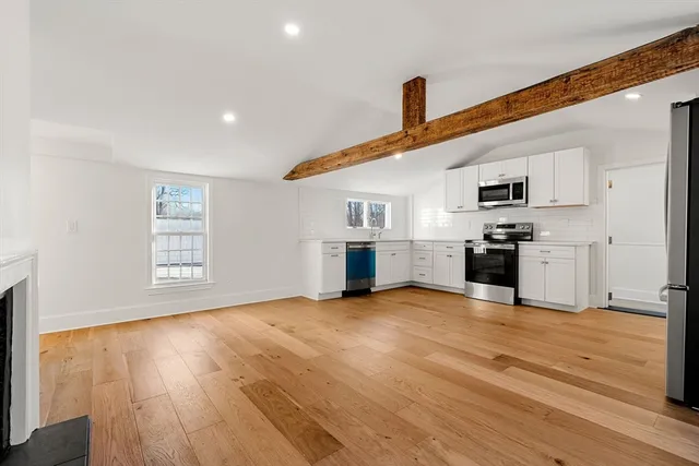 a view of empty room with wooden floor and fireplace