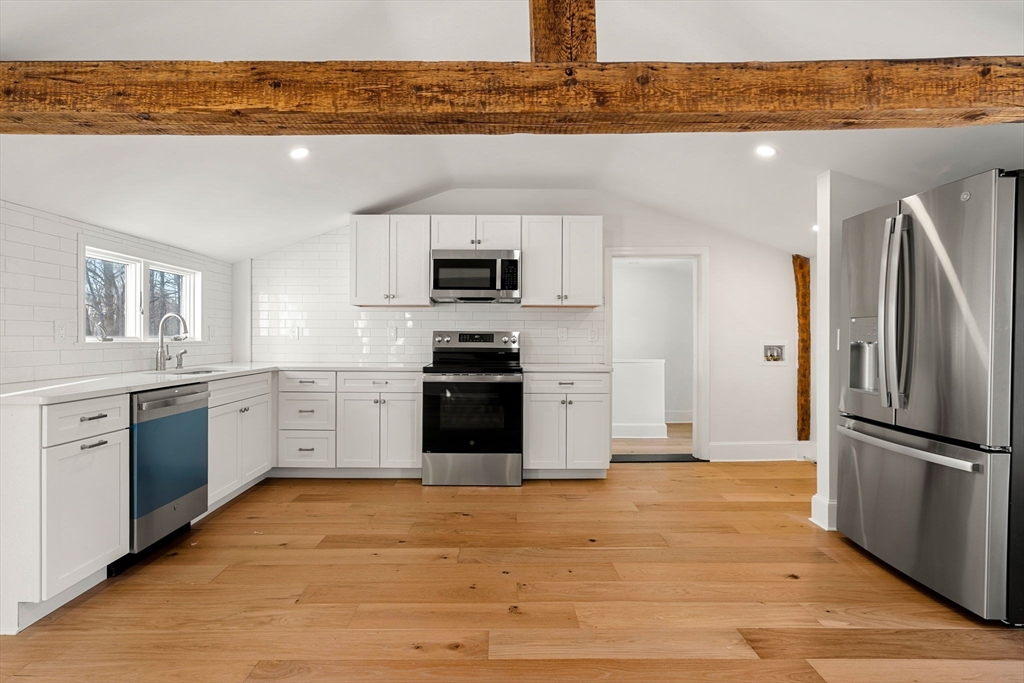 34 Central Street, Unit 2 Rowley, MA 01969 - Photo 6 of 29 a kitchen with granite countertop a refrigerator stove top oven and sink