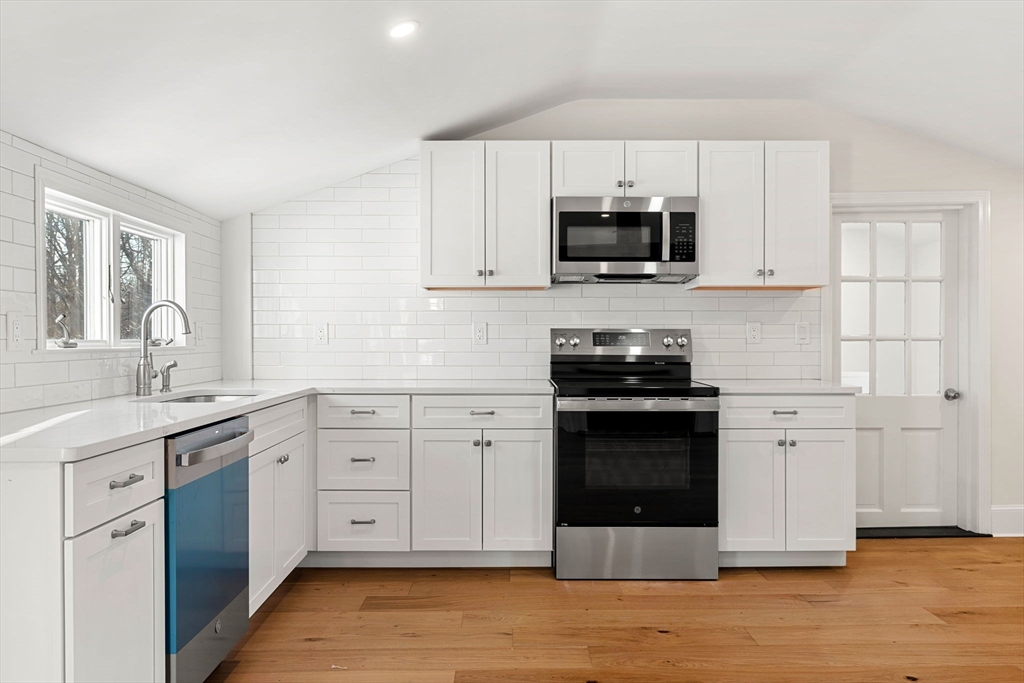 34 Central Street, Unit 2 Rowley, MA 01969 - Photo 7 of 29 a kitchen with stainless steel appliances granite countertop a stove a sink and a microwave