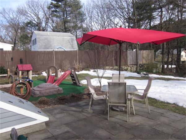 32 Davidson Road Framingham, MA 01701 - Photo 29 of 30 a view of a patio with table and chairs under an umbrella with barbeque grill and wooden fence