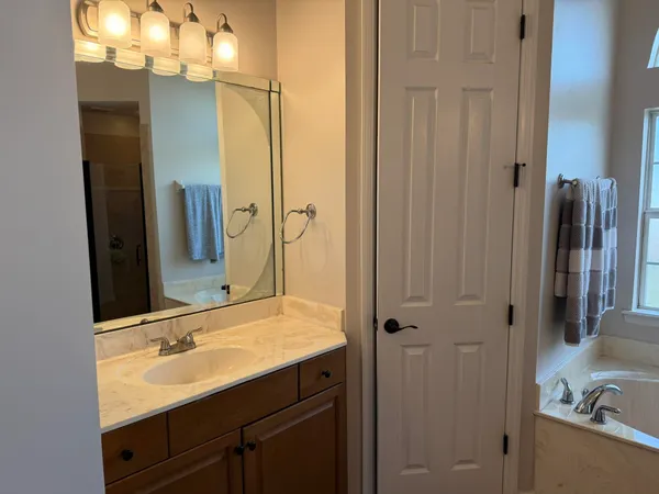 a bathroom with a granite countertop sink a toilet and mirror