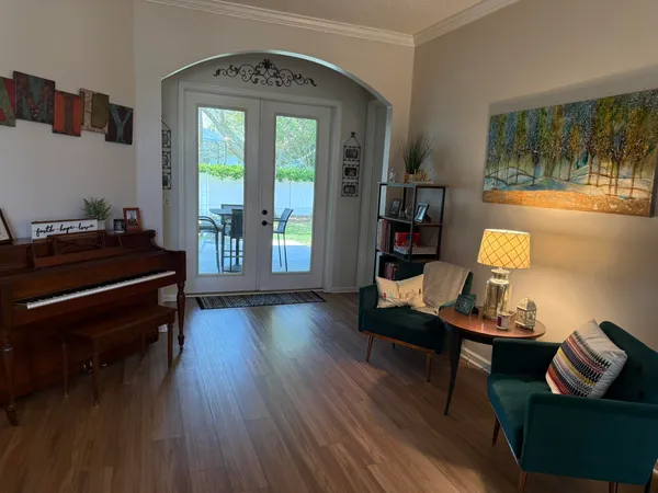 a dining room with furniture a chandelier and wooden floor