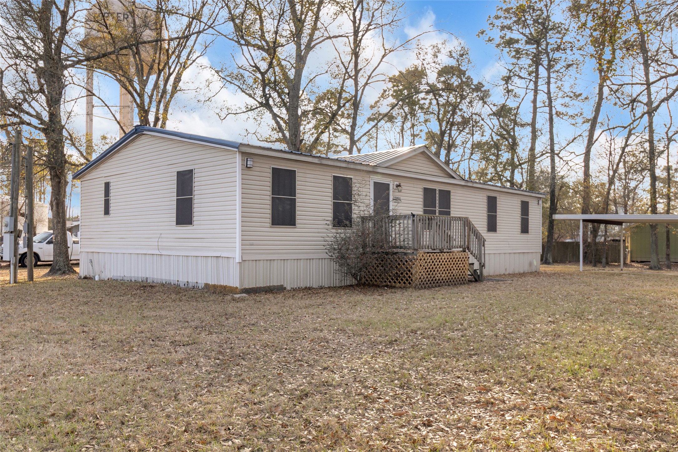 22094 Spear Road Porter, TX 77365 - Photo 35 of 45 Small deck, situated on a spacious, grassy lot surrounded by trees, offering a peaceful setting.