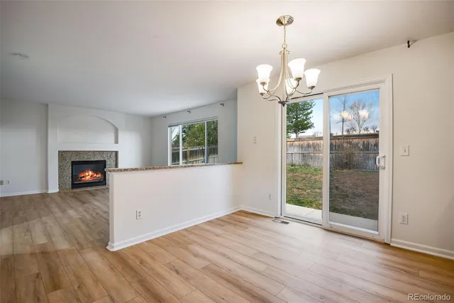 a view of a room with wooden floor fireplace and windows