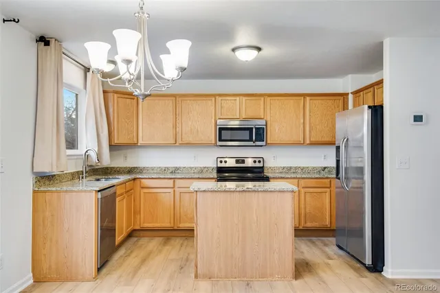 a kitchen with stainless steel appliances granite countertop a stove a sink dishwasher and a refrigerator