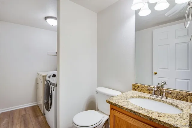 a bathroom with a granite countertop sink toilet and a mirror