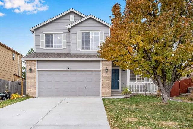 a front view of a house with a garden and trees
