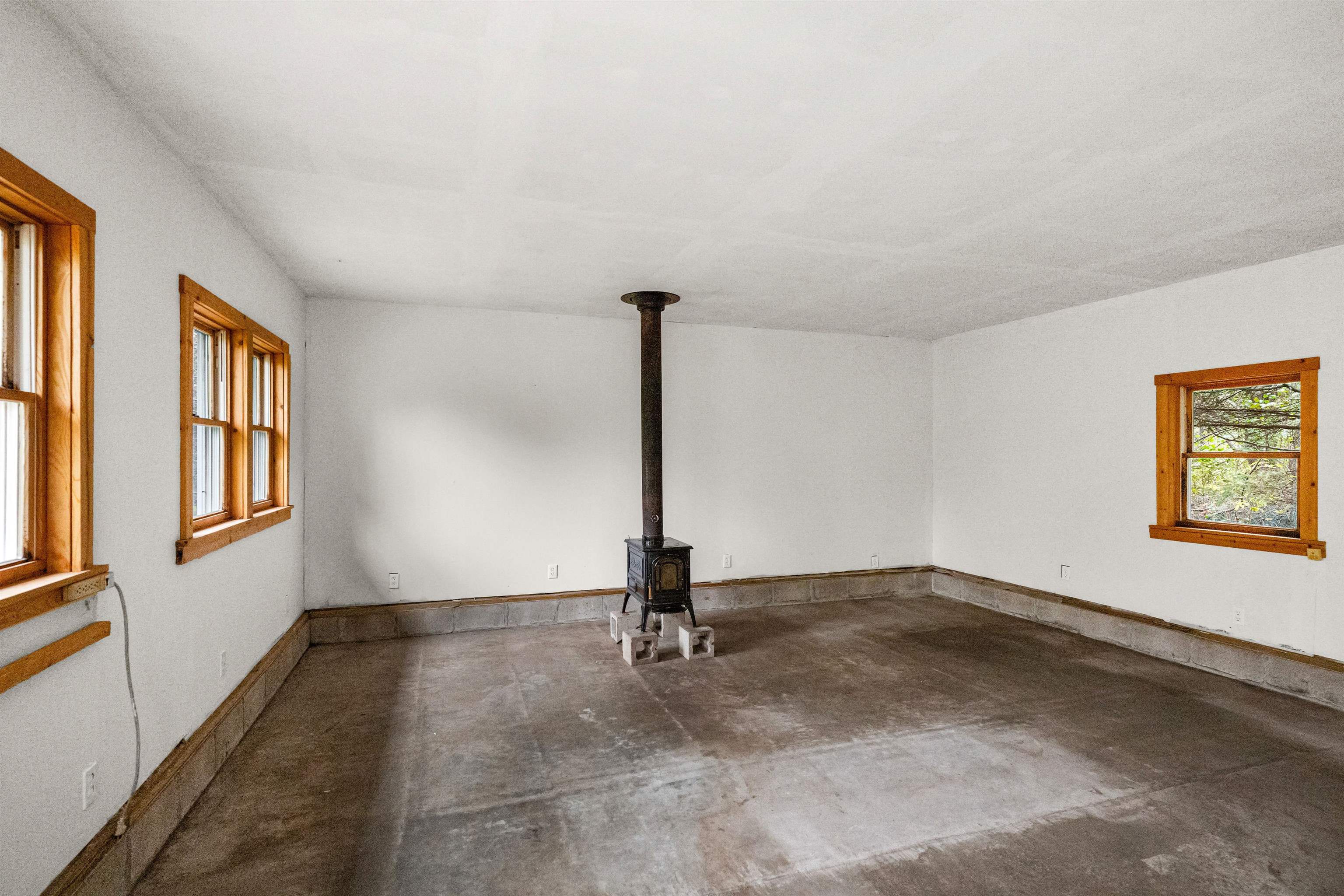 6264 Ryan Road Duluth, MN 55804 - Photo 13 of 30 Empty room with a wood stove and concrete floors