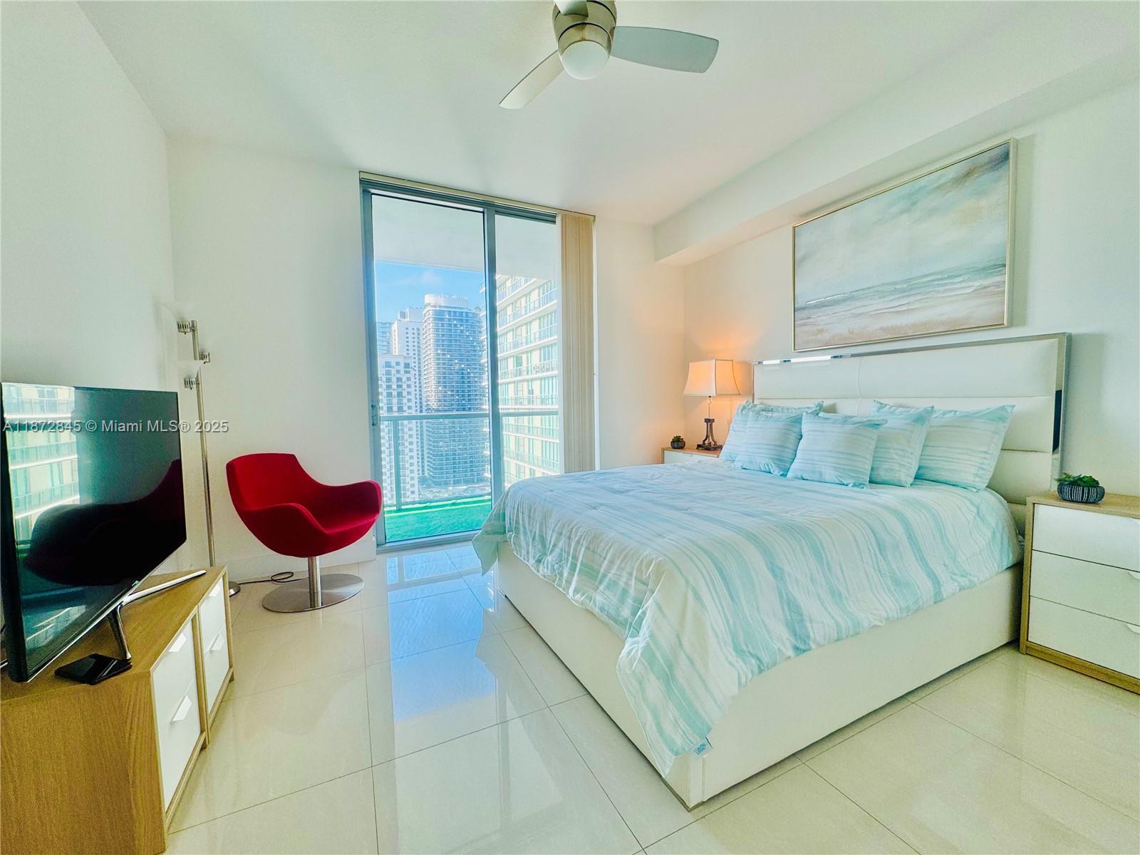 79 Southwest 12th Street, Unit 3211S Miami, FL 33130 - Photo 12 of 32 a bedroom with a bed and a chandelier